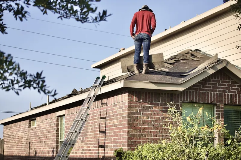 Professional roofer working on a residential roof in Random Hills